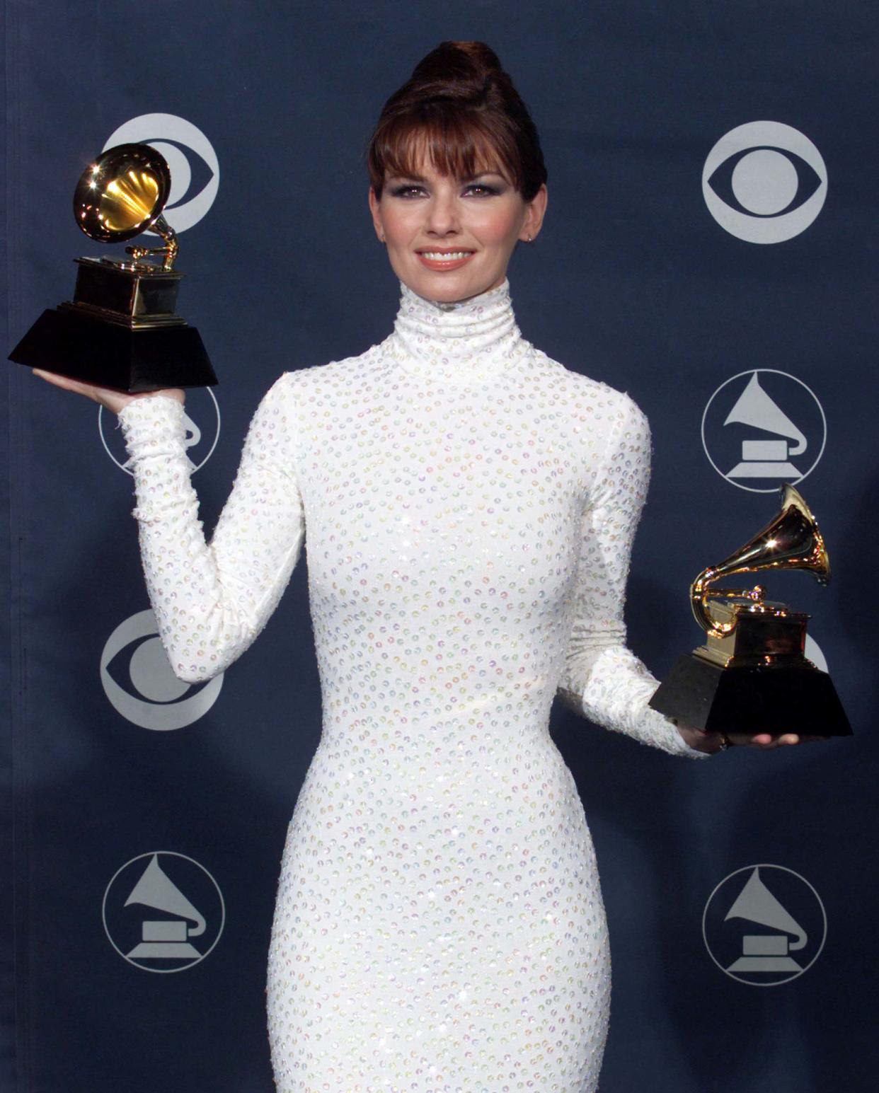 Country music singer Shania Twain poses with the two Grammy Awards she won at  the Shrine Auditorium February 24 at  the 1999 Grammy Awards in Los Angeles. [Twain won awards for Best Female Country Vocal Performance for 