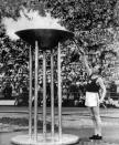 Runner Paavo Nurmi, of Finland, lights the Olympic flame from the Olympic torch, during July 19, 1952, opening ceremony in Helsinki, Finland. (AP Photo)