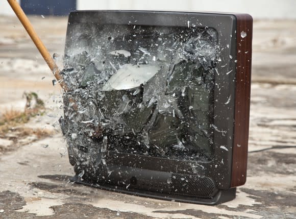 A tool shatters the glass of a TV set.