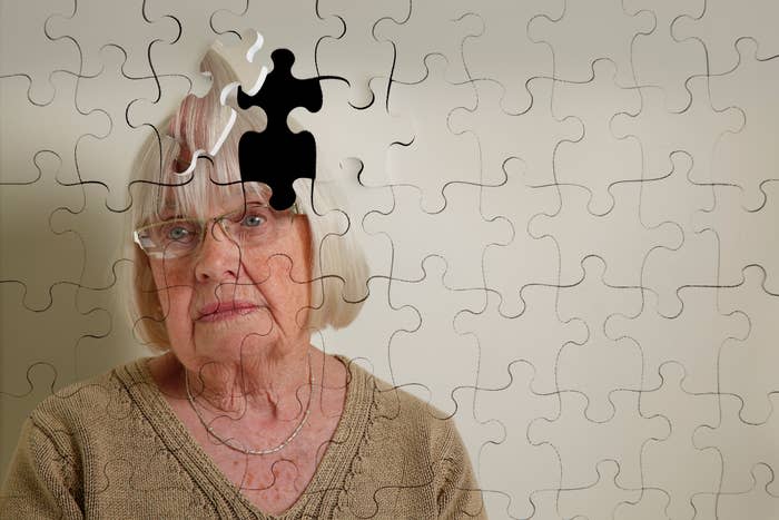 An elderly woman with gray hair and glasses is depicted as a puzzle with a missing piece over her head