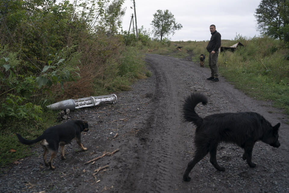 Anatolii Klyzhen stands next to the remains of a cluster-type munition in the freed village of Hrakove, Ukraine, Tuesday, Sept. 13, 2022. Russian troops occupied this small village southeast of Ukraine’s second largest city of Kharkiv for six months before suddenly abandoning it around Sept. 9 as Ukrainian forces advanced in a lightning-swift counteroffensive that swept southward. (AP Photo/Leo Correa)