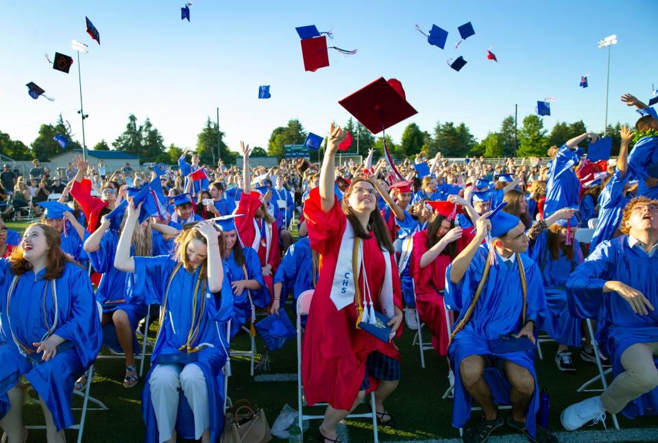 Churchill High graduate Sonja Nusser, center, joins fellow graduates in throwing their mortarboard in the air after a commencement ceremony on the football field at the high school June 17, 2021.