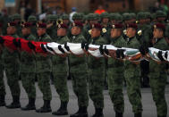 Soldiers hold a Mexican national flag as they prepare to raise it at half-staff during a ceremony marking the 34th anniversary of the 1985 earthquake, in Mexico City, Thursday, Sept. 19, 2019. The 8.1-magnitude earthquake killed as many as 10,000 and left thousands homeless. The date also commemorates the 2017 earthquake that rattled the city killing hundreds. (AP Photo/Marco Ugarte)