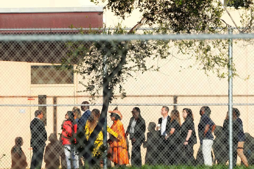 Nine members of Congress wait to enter Marjory Stoneman Douglas High School in Parkland on Friday. The group will tour the blood-stained and bullet-pocked halls, shortly before ballistics technicians reenact the massacre that left 14 students and three staff members dead in 2018. The reenactment is part of a lawsuit filed by the victims' families against former Deputy Scot Peterson and the Broward Sheriff's Office. (AP Photo/Marta Lavandier)