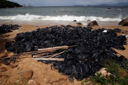 FILE PHOTO: Garbage bags containing collected crystallised palm oil are seen on a beach at Lamma Island in Hong Kong, China August 9, 2017. REUTERS/Bobby Yip/File Photo