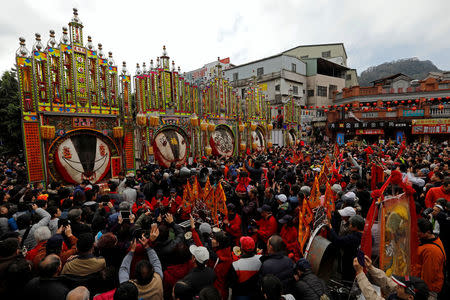 Worshippers gather around the decorated carcasses of sacrificial pigs, winners of the "holy pig" contest in Sanxia district, in New Taipei City, Taiwan February 2, 2017. REUTERS/Tyrone Siu