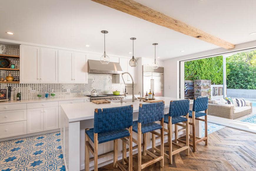 The all-white kitchen has a breakfast bar and large chef's oven.