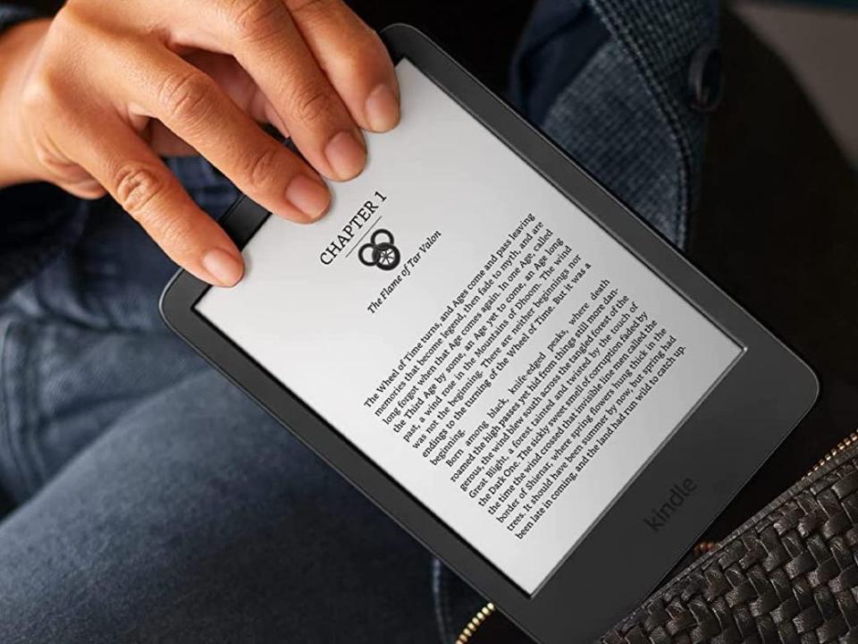 Image of a person holding the All-New Kindle and placing it in their bag.