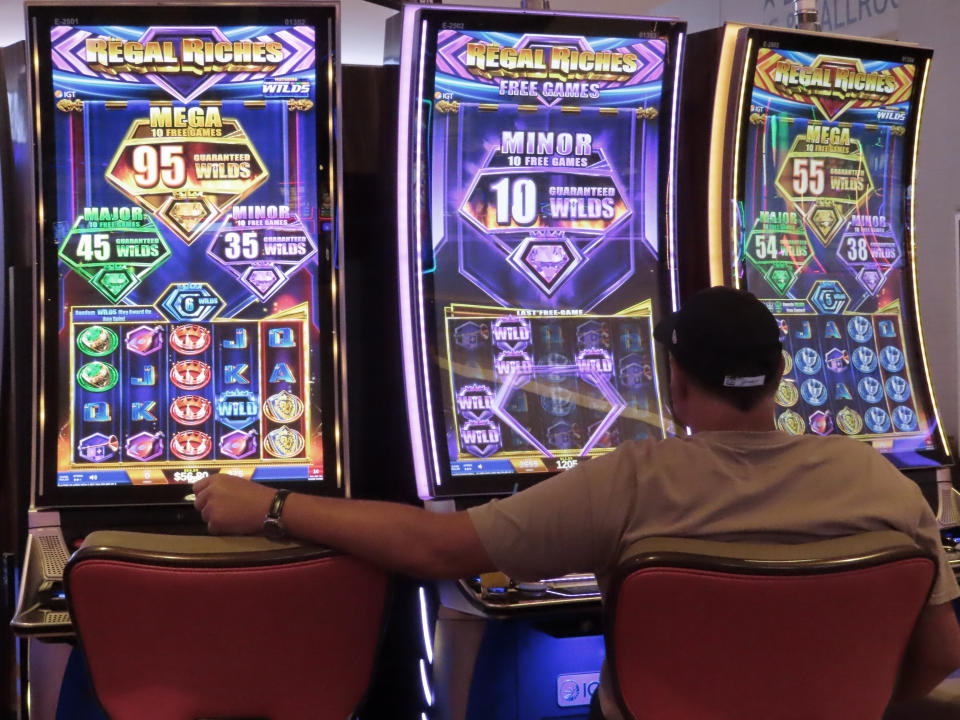 A man plays a slot machine at the Hard Rock Casino in Atlantic City N.J. on Aug. 8, 2022. On Sept. 16, 2022, New Jersey gambling regulators reported that the state's casinos, horse tracks that offer sports betting and the online partners of both types of gambling outlets won $470.6 million from gamblers in August, up nearly 10% from a year earlier. (AP Photo/Wayne Parry)