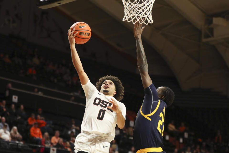 Oregon State guard Jordan Pope (0) drives to the basket as California forward Obinna Anyanwu, right, defends during the first half of an NCAA college basketball game in Corvallis, Ore., Saturday, March 4, 2023. (AP Photo/Amanda Loman)