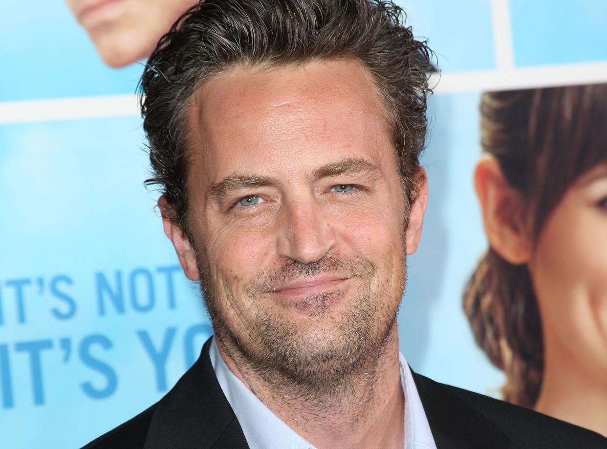 Actor Matthew Perry smiles at the camera at a red carpet event.