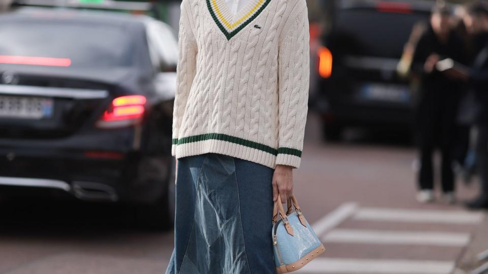 Veronika Heilbrunner seen wearing  cream and black Lacoste sweater, white shirt, blue denim jeans skirt and black boots with tan and light blue bag outside Lacoste Show during the Womenswear Fall/Winter 2024/2025