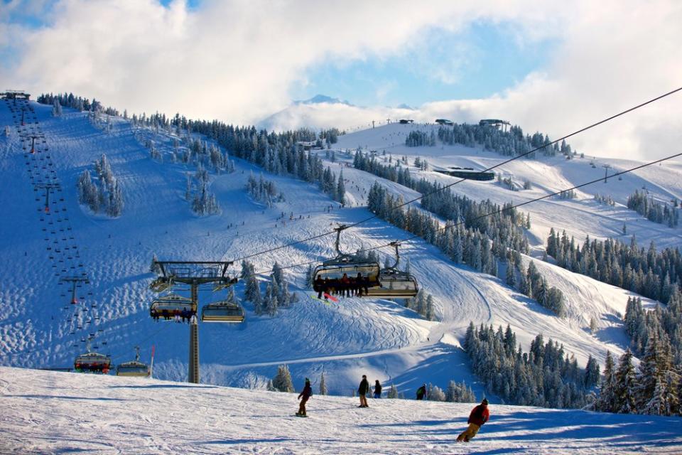Chair lifts and skiers in mountains of Austrian ski resort