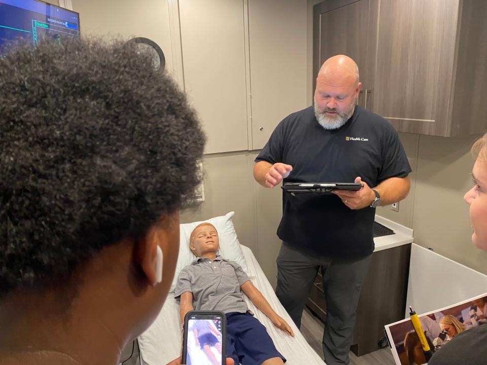 EMT Jeremy Tuggle on Friday reviews stats for an interactive mannequin in MU Health Care's Mobile Simulation Lab during its Tomorrow's Health Care Experts Expo at Hilton Garden Inn & Expo Center.