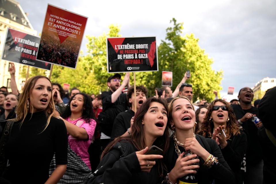 People react to the projection of results during the second round of the legislative elections, near Republique Plaza in Paris, France, Sunday, 7 July 2024 (AP)