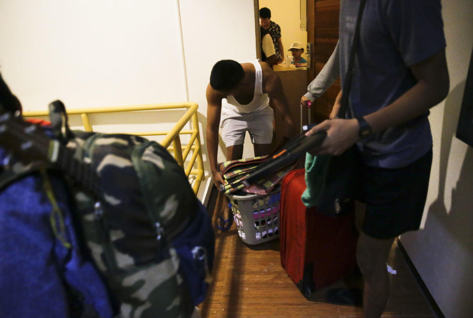 Guests prepare to transfer rooms after the roof was partly damaged due to strong winds from Typhoon Mangkut in Tuguegarao city, Cagayan province, northeastern Philippines on Saturday, Sept. 15, 2018. Typhoon Mangkhut slammed into the country's northeastern coast early Saturday, with witnesses saying the storm's ferocious wind and blinding rain ripped off tin roof sheets and knocked out power at the start of the onslaught. (AP Photo/Aaron Favila)