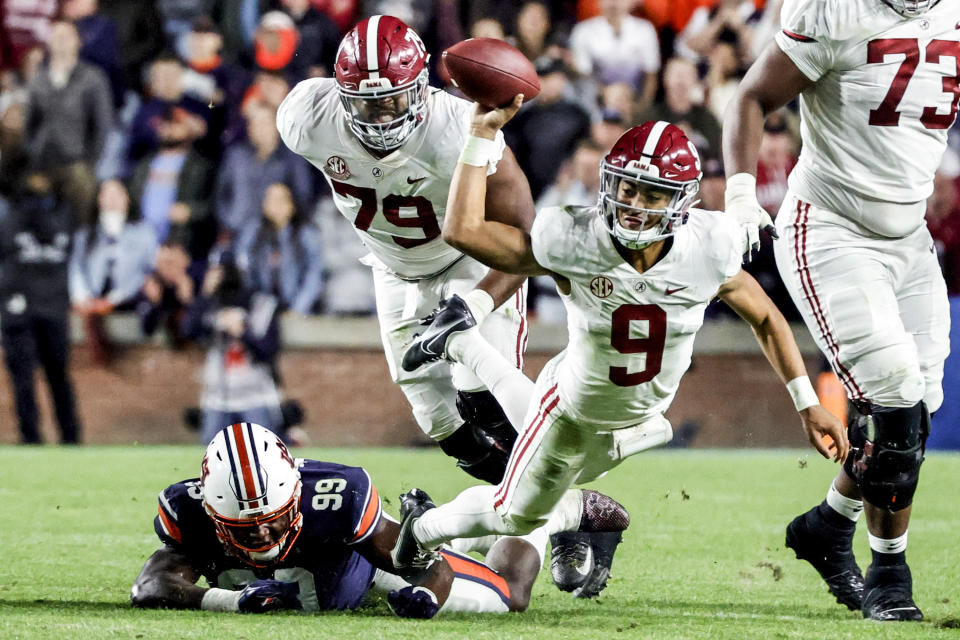 Alabama quarterback Bryce Young (9) is tacked as he tries to pass by Auburn defensive end T.D. Moultry (99) during the second half of an NCAA college football game Saturday, Nov. 27, 2021, in Auburn, Ala. (AP Photo/Butch Dill)