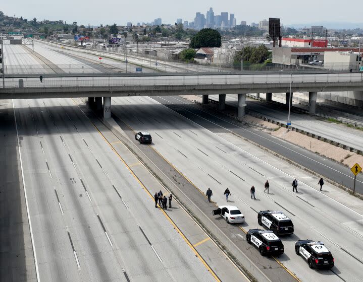 Monterey Park, CA - March 31: Police investigators line I-10 Freeway to look for evidence after police fatally shot a suspect (driving the white car) who apparently bailed out of a vehicle and ran across the San Bernardino (10) Freeway in the City Terrace area today, prompting a full closure of the highway and causing extensive backups in both directions. Photo taken in Monterey Park Friday, March 31, 2023. The shooting occurred late Friday morning on the 10 Freeway just east of the Long Beach (710) Freeway. The California Highway Patrol initially announced that all eastbound lanes of the freeway were closed at Eastern Avenue, but the westbound side of the heavily traveled freeway was also shut down to accommodate the investigation.(Allen J. Schaben / Los Angeles Times)