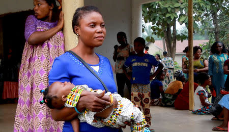 A still image taken from a video shot on December 9, 2017 shows a Cameroonian refugee woman carrying a child outside a center in Agbokim Waterfalls village, which borders on Cameroon, Nigeria. REUTERS/via Reuters TV