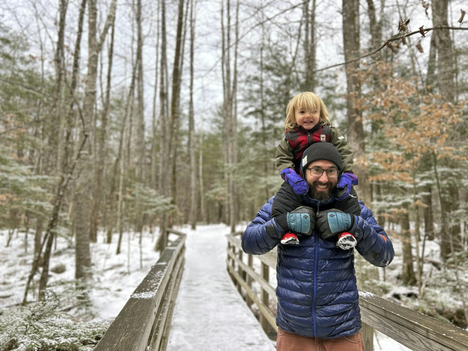 Christopher Roma, the expert hiker who completed the Triple Crown of challenging cross-country trails, carries his son Solomon on his shoulders in the White Mountains in New Hampshire in late 2023. Roma was found dead near Mount Guyot this week during a hike in brutal weather conditions. (Megan Roma Sullivan via AP)