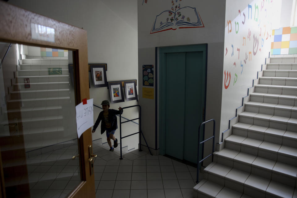 A Ukrainian refugee child walks up the stairs at the Lauder Morasha Jewish school in Warsaw, Poland, Thursday, July 28, 2022. A special summer camp run by Jewish organizations has brought Jewish volunteers from the former Soviet Union to Warsaw to help Ukrainian children. The camp, which ran for most of July and ended Friday, was organized to bring some joy to traumatized children, help prepare them for the school year ahead in Polish schools and give their mothers some time to themselves. (AP Photo/Michal Dyjuk)