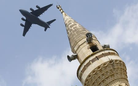 A U.S. Air Force Boeing C-17A Globemaster III large transport aircraft flies over a minaret after taking off from Incirlik air base in Adana, Turkey, in this August 12, 2015 file photo. REUTERS/Murad Sezer/Files
