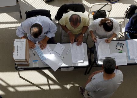 Funcionarios electorales trabajan en una escuela pública usada como local de votación durante el balotaje en Buenos Aires, Argentina, el 22 de noviembre de 2015. Los argentinos votaban el domingo en una inédita segunda vuelta presidencial que decidirá la profundidad y ritmo de cambios a un modelo económico de fuerte intervención estatal herido por la falta de divisas. REUTERS/Martin Acosta - RTX1VA60