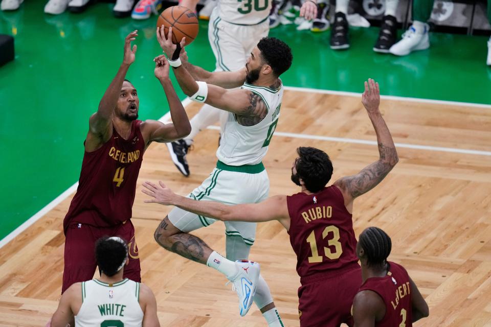 Boston Celtics forward Jayson Tatum (0) drives to the basket against Cleveland Cavaliers forward Evan Mobley (4) during the first half of an NBA basketball game, Wednesday, March 1, 2023, in Boston. At right is Cavaliers guard Ricky Rubio (13). (AP Photo/Charles Krupa)