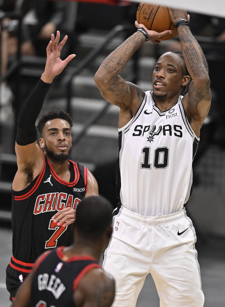DeMar DeRozan, de los Spurs de San Antonio, dispara frente a Troy Brown Jr, de los Bulls de Chicago, en el encuentro del sábado 27 de marzo de 2021 (AP Foto/Darren Abate)