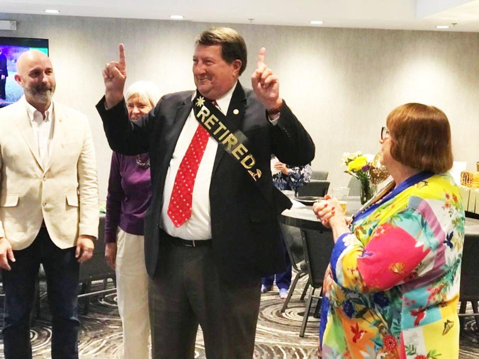 Oak Ridge City Manager Mark Watson jokes around after being presented by Oak Ridge Mayor Warren Gooch, not shown, with a "Retired" sash to wear. From left is Oak Ridge City Council members Jim Dodson, Ellen Smith and Watson's wife, Jenna.