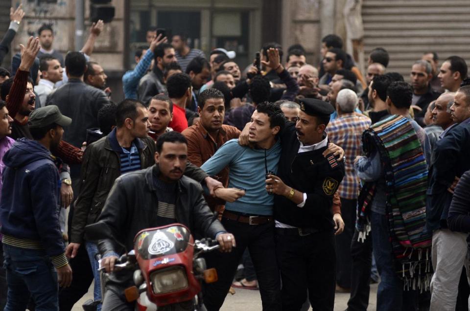 FILE - In this Saturday, Jan. 25, 2014 file photo, a supporter of Egypt's ousted President Mohammed Morsi is detained by police during clashes with security forces in downtown Cairo, Egypt. On Tuesday, Feb. 11, 2014, the third anniversary of the day Hosni Mubarak stepped down as Egypt’s president after an 18-day uprising, the government blocked access to Tahrir Square and letters emerged from activists reporting that they have been beaten and subjected to other abuses by police after being arrested in a string of protests in late January. (AP Photo/Ahmed Gamil, File)