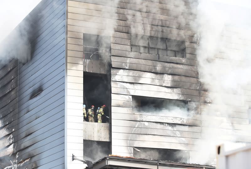 Firefighters try to put out fire as smoke rises from a warehouse which is currently under construction, after it caught fire, in Icheon