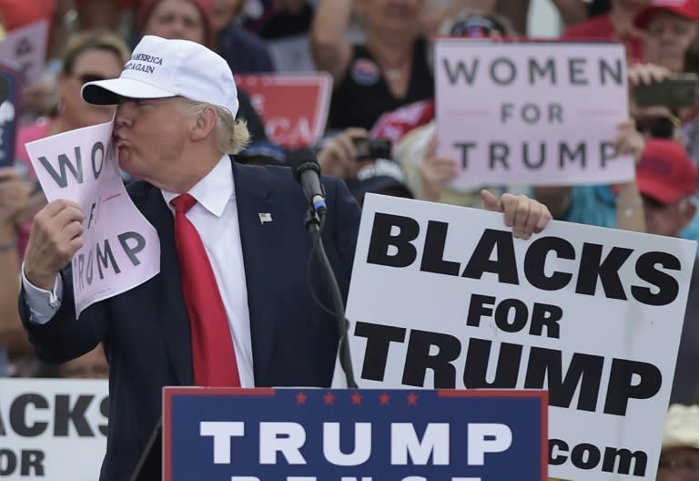 File photo shows then Republican presidential nominee Donald Trump kissing a "Women for Trump" placard during a rally in Florida