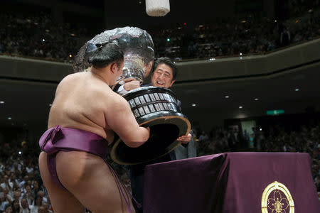 Japanese Prime Minister Shinzo Abe presents the Prime Minister’s Cup to wrestler Asanoyama, the winner of the Summer Grand Sumo Tournament at Ryogoku Kokigikan Sumo Hall in Tokyo, Japan May 26, 2019. REUTERS/Jonathan Ernst