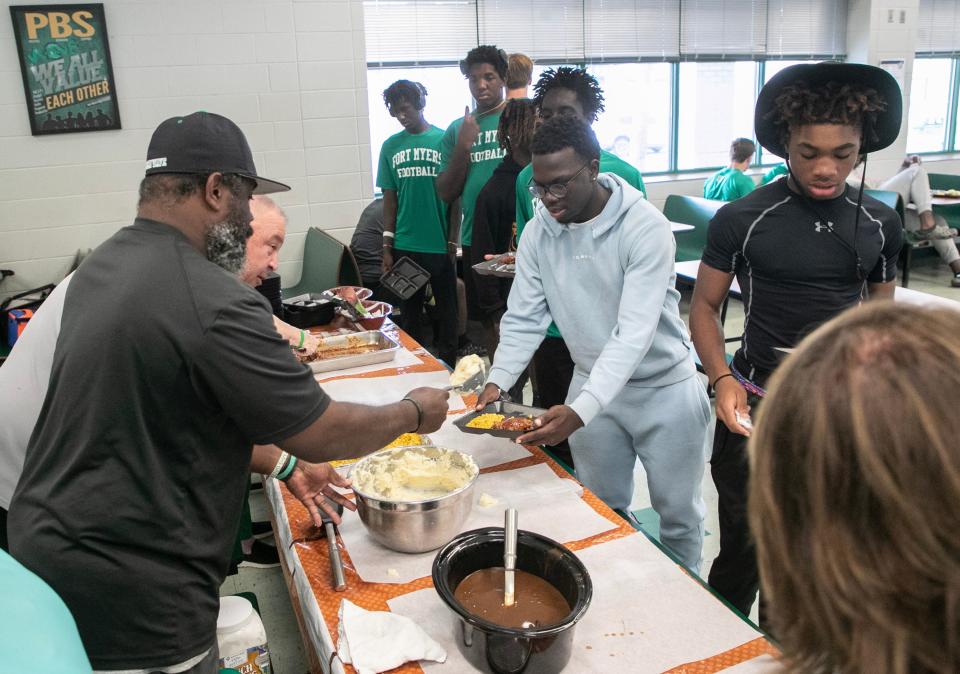 Fort Myers High football coaches serve players their pre-game meal on Thursday, Oct. 19, 2023, at Fort Myers High School.