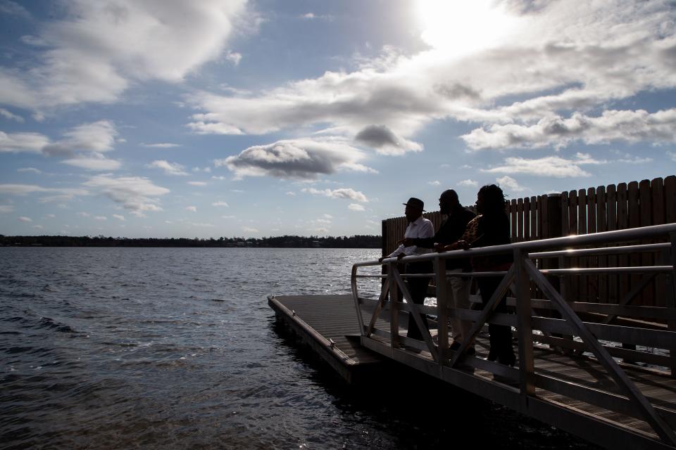 Fred Flowers, the attorney for Tarina White's family, left, and Kimbra Williams, White's sister, right, look out at Compass Lake where White's body was found inside a truck that was submerged in the water seven years ago.