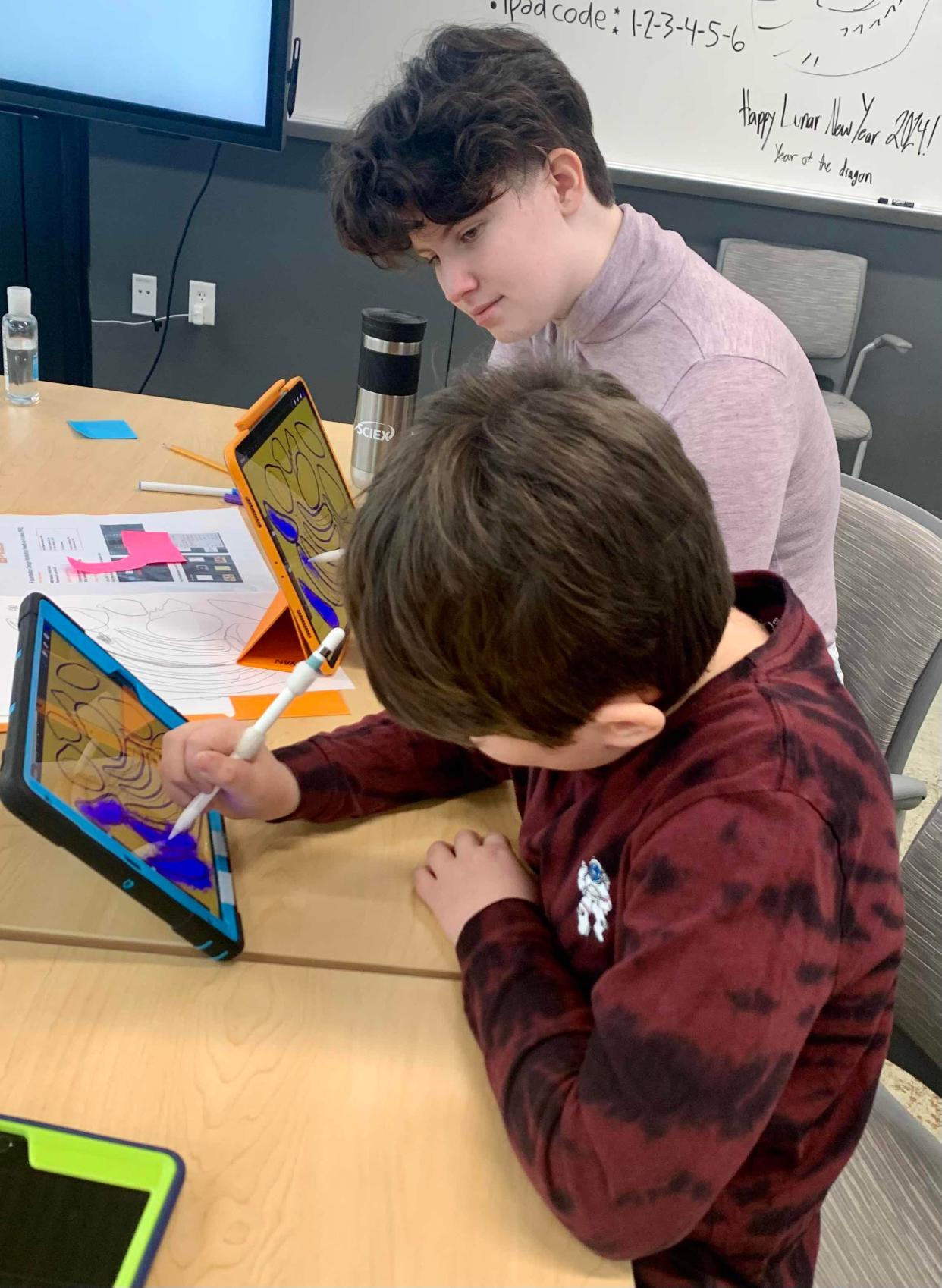 Islands of Brilliance student, Neven, works with mentor Monty on a technology-based art project.
