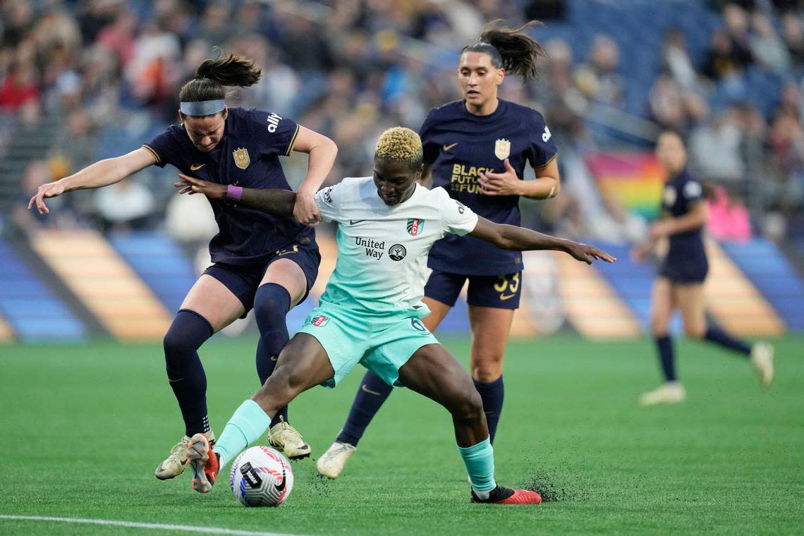 Kansas City Current forward Temwa Chawinga works to control the ball between Seattle Reign FC players Phoebe McClernon, left, Olivia Van der Jagt during Wednesday night’s NWSL match at Lumen Field in Seattle. Stephen Brashear/USA TODAY Sports