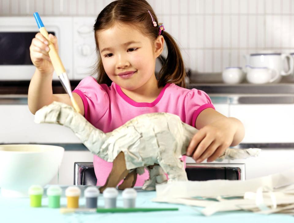 young girl in kitchen, making paper dinosaur, smiling fun activities for kids