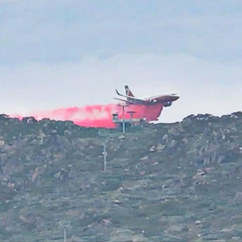 A plane releases fire retardant on an area in Perisher Valley, New South Wales, Australia, in this January 10, 2020 image obtained from social media