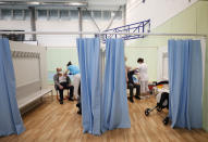 Elderly men receive Moderna COVID-19 vaccine at a sports hall in Ricany, Czech Republic, Friday, Feb. 26, 2021. With new infections soaring due to a highly contagious coronavirus variant and hospitals filling up, one of the hardest-hit countries in the European Union is facing inevitable: a tighter lockdown. (AP Photo/Petr David Josek)