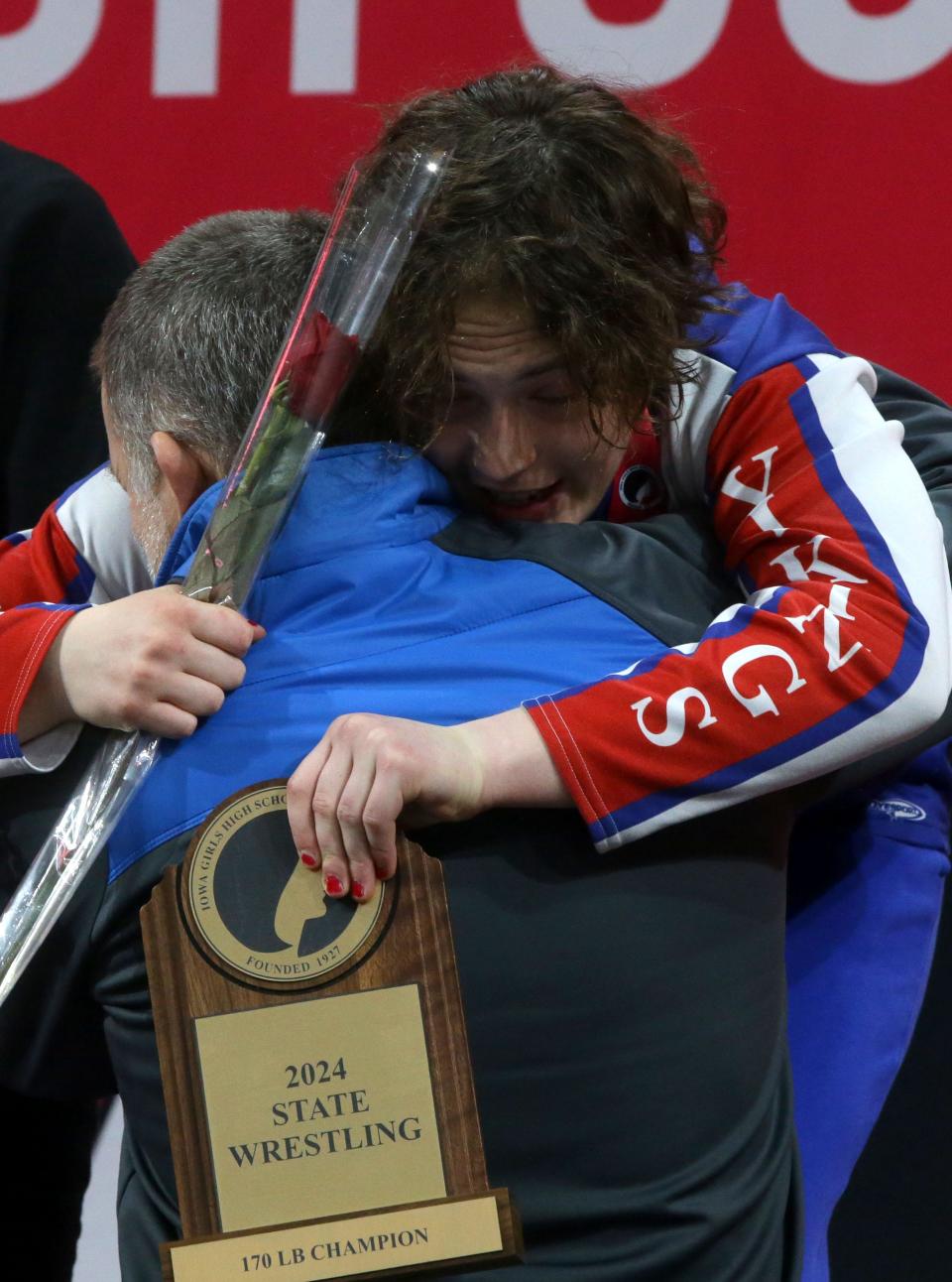 Decorah’s Naomi Simon hugs her coach after becoming Iowa's first four-time state girls wrestling champion Friday at Xtream Arena in Coralville.