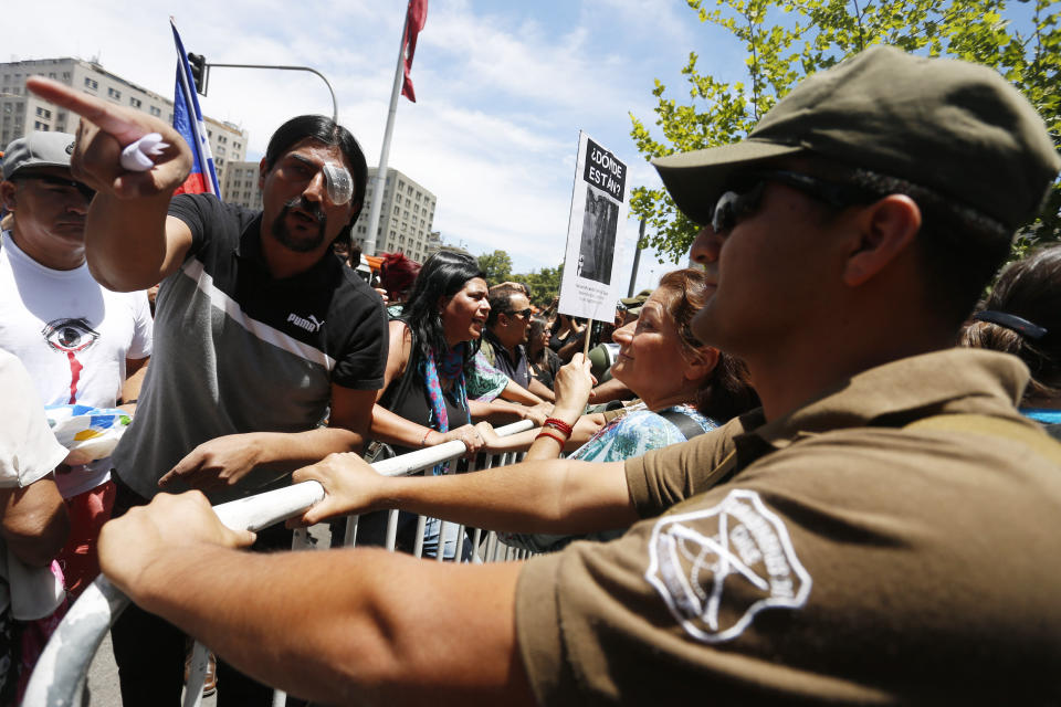 Demonstrators who claim they lost an eye after being shot with a shotgun by the police during the ongoing anti-government demonstrations, participates in a protest in front of Palacio de La Moneda, in Santiago, Chile, Friday, Dec. 13, 2019. The United Nations released on Friday a report which stated that there have been serious violations of human rights during the repression of recent protests in Chile. (AP Photo/Luis Hidalgo)