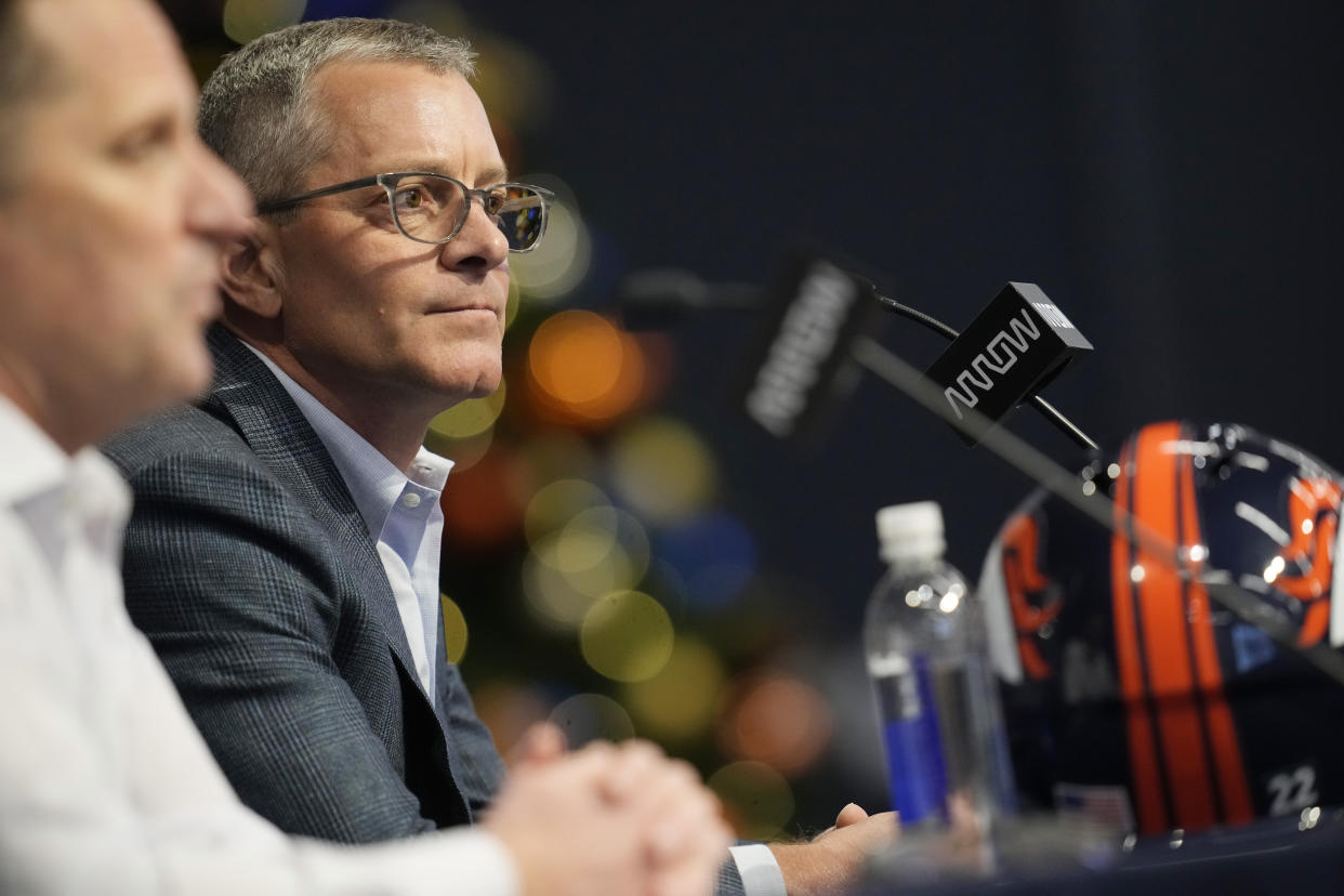 Denver Broncos CEO Greg Penner (background) listens as general manager George Paton responds to a question during a news conference in December. (AP Photo/David Zalubowski)
