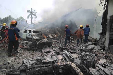 Firemen attempt to extinguish the fire surrounding the wreckage of an Indonesian military transport plane after it crashed in the North Sumatra city of Medan, Indonesia, June 30, 2015 in this photo taken by Antara Foto. REUTERS/Irsan Mulyadi/Antara Foto