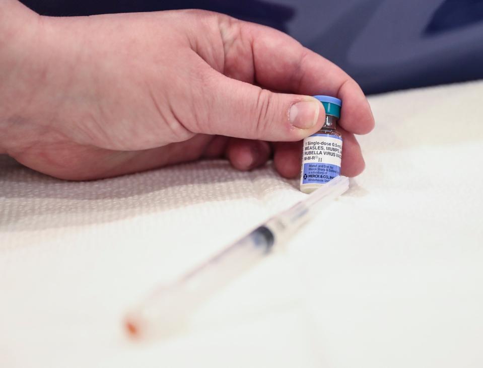 A nurse holds a vile of the Measles, Mumps & Rubella (MMR) vaccine at the Robert L. Yeager health complex in Pomona on Wednesday, March 27, 2019.