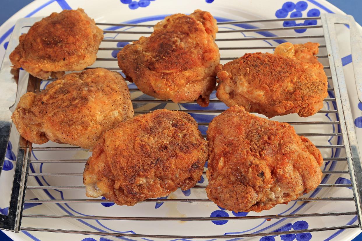 fried chicken thighs on metal cooling rack