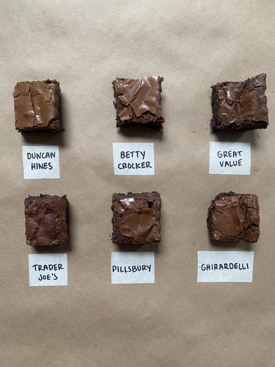 Six brownies labeled with brand names Duncan Hines, Betty Crocker, Great Value, Trader Joe's, Pillsbury, and Ghirardelli for comparison
