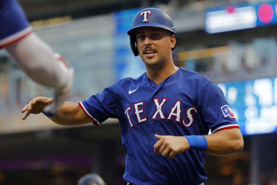 Texas Rangers' Nate Lowe returns to the dugout after scoring against the Minnesota Twins during the third inning of a baseball game Thursday, Aug. 24, 2023, in Minneapolis. (AP Photo/Bruce Kluckhohn)