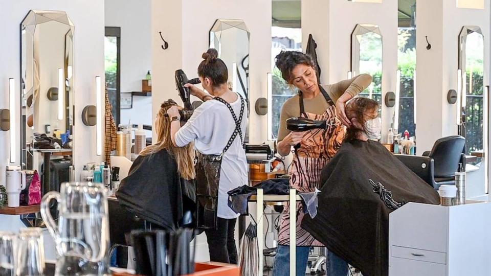 Hairstylist Kathryn Sanchez, center right, works with a client in the salon section of Genesis Bistro & 8028 Salon. The hair salon stays open close to the same hours as the bistro.